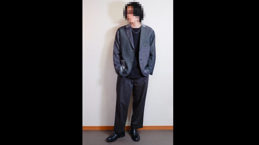 グレーが土台のチェックのジャケットに、黒のインナー、チャコールグレーのパンツ、黒の革靴を合わせた着こなし