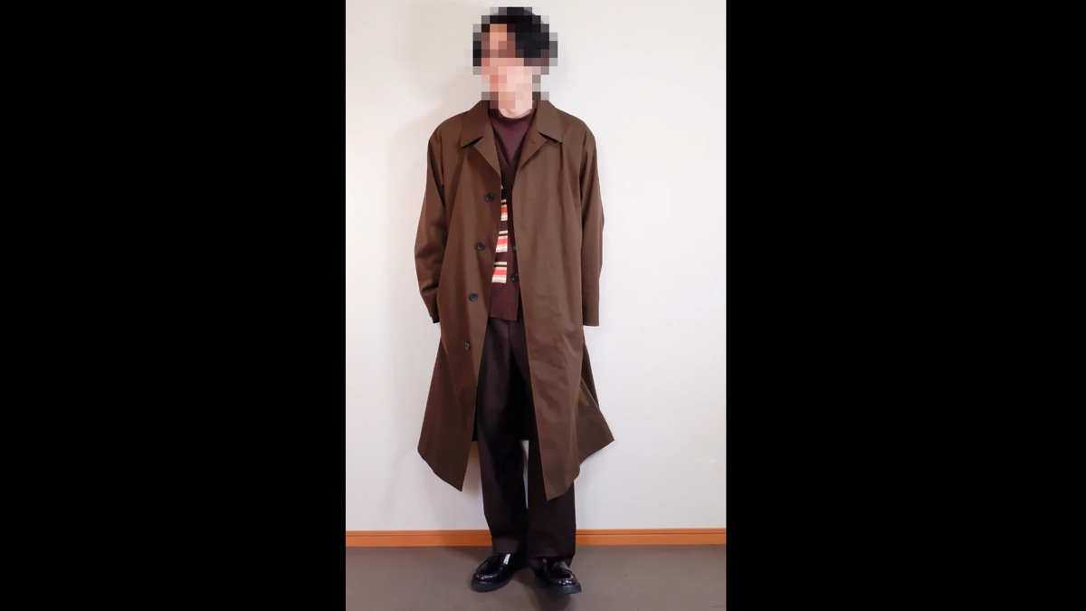 色や柄を1つ足した冬の格好（ブラウンのロングコート、ボルドーのモックネック、白とオレンジのストライプが入ったブラウンのカーディガン、ダークブラウンのパンツ、黒のローファー）